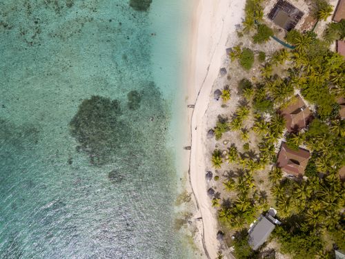 Free Stunning aerial shot of a pristine beach with turquoise water and lush greenery. Stock Photo