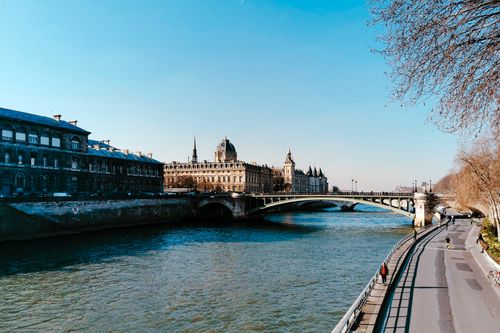 Free Stunning view of the Seine River with historic Parisian buildings and a clear blue sky, perfect for travel inspiration. Stock Photo
