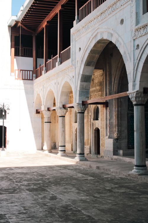 Free Elegant arched courtyard featuring stone columns and classic architecture, highlighting historical design. Stock Photo