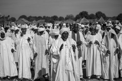 Free Traditional Islamic prayer gathering in rural setting captured in black and white. Stock Photo