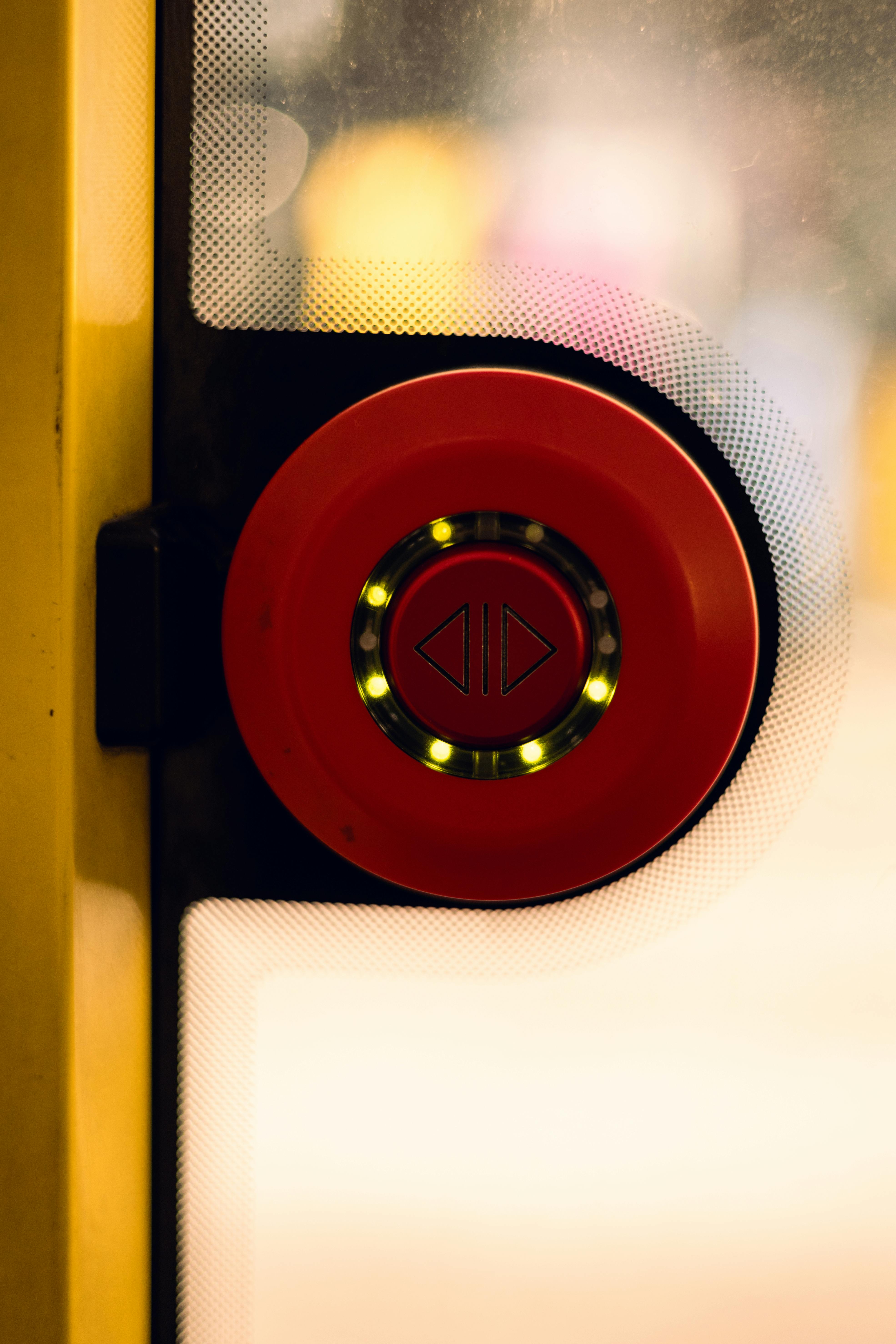 Free Detailed view of a red stop button on a tram window, highlighting public transportation features. Stock Photo