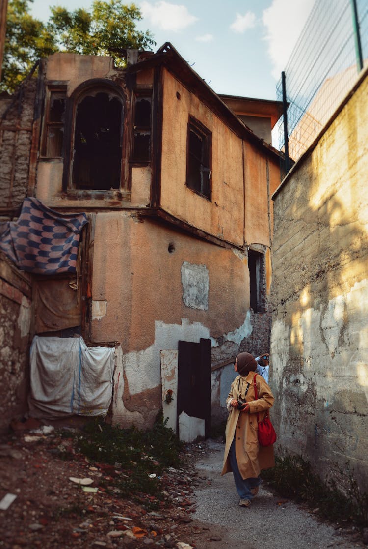 Woman Walking Near House In Town