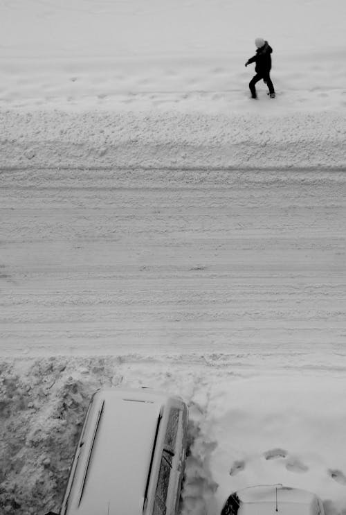 Person Walking in Snow near Road
