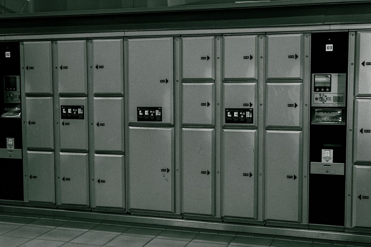 Row of secure storage lockers with an electronic payment panel at a terminal