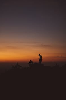 日落时分，人们在露营时剪影，捕捉风景如画的天空和自然