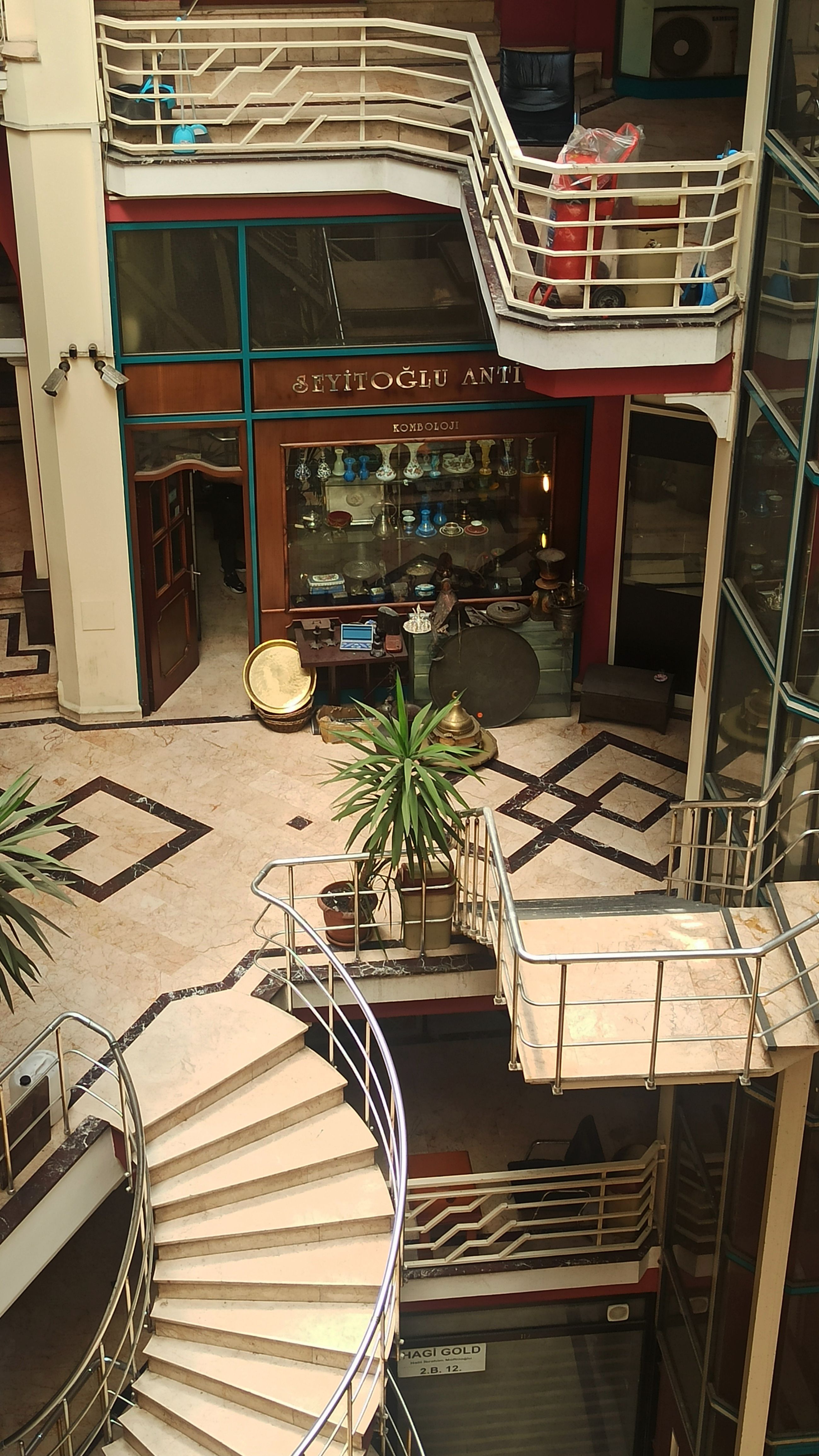 View of a vintage shopping mall interior in Istanbul's Fatih district, showcasing spiral staircases and antique store.
