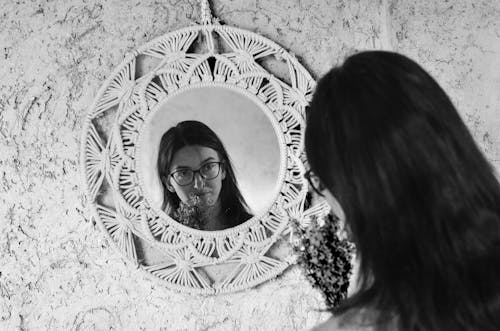 Woman with Eyeglasses Looking at Her Reflection in Mirror