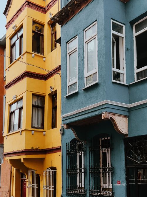 Free Vibrant yellow and blue buildings in a historic Istanbul street showcasing unique architectural details. Stock Photo