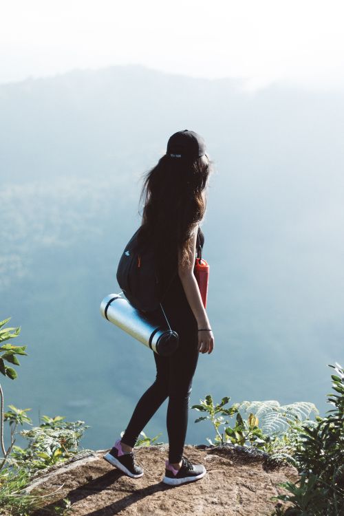 Free A lone female hiker enjoys a scenic mountain view on a summer day. Stock Photo