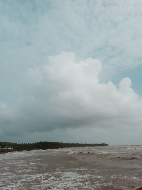 Free Peaceful seaside scene with cloudy sky and waves. Perfect for relaxing and nature themes. Stock Photo