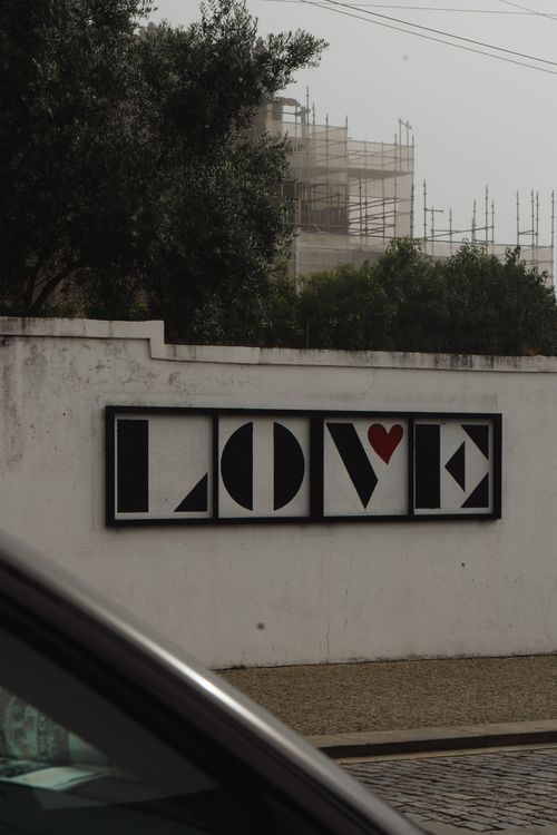 Free A creative love sign on a white urban wall, featuring unique design elements. Stock Photo