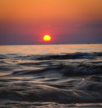 Peaceful sunset view with vibrant colors reflecting on tranquil ocean waves.