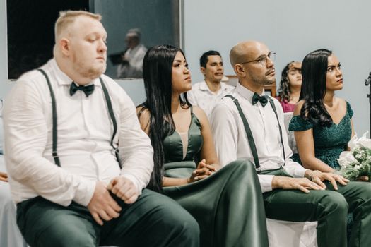 Elegant wedding guests seated attentively at a ceremony venue.