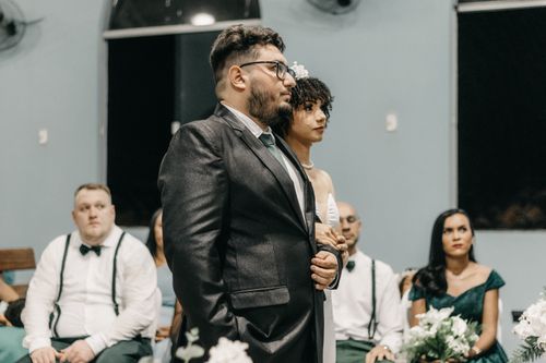 Free Elegant portrait of a bride and groom standing at their wedding ceremony, surrounded by the wedding party. Stock Photo