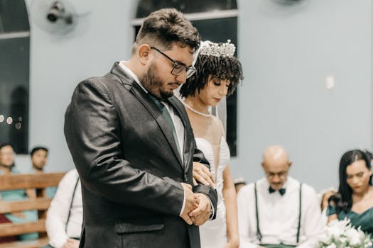 Bride and groom in a solemn moment at their wedding ceremony, surrounded by guests.