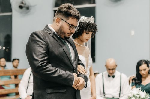 Free Bride and groom in a solemn moment at their wedding ceremony, surrounded by guests. Stock Photo