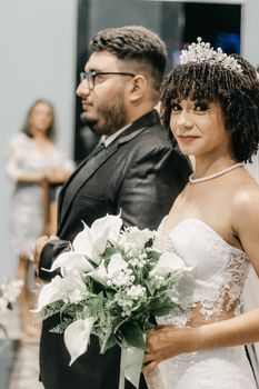Bride and groom standing together during a beautiful wedding ceremony indoors.