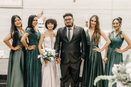 Newlyweds and Guests in Dresses at Wedding
