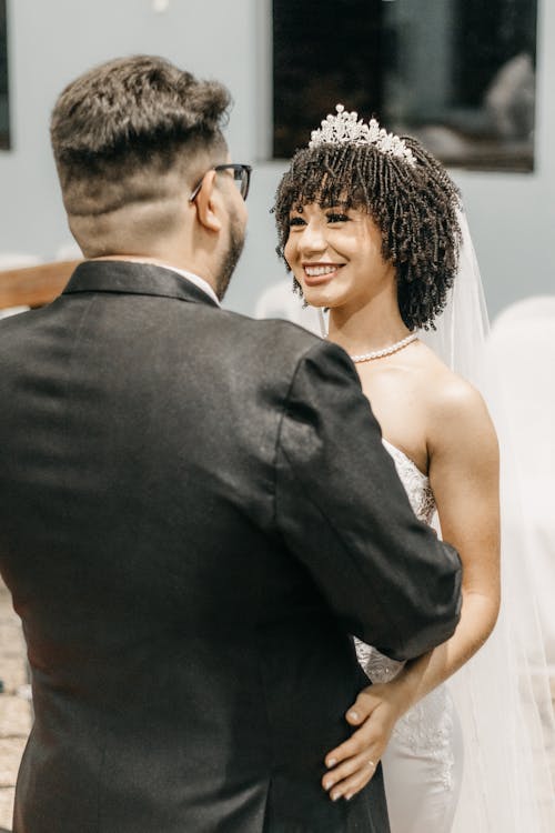 Photo of Bride and Groom Embracing and Smiling 
