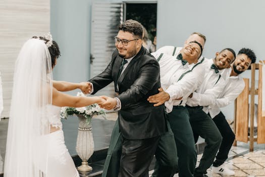 Newlyweds and groomsmen in a lighthearted dance at a fun wedding celebration.