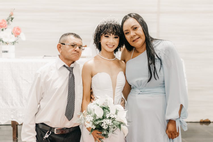 Bride Posing For A Photo With Her Parents 