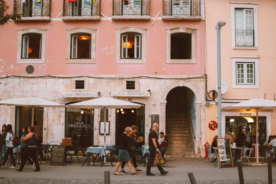 A vibrant café scene in Lisbon featuring <span class="notranslate"><em>Sagres Beer</em></span> bottles and lively conversation.