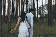 一对夫妇手牵着手，走在宁静的森林里