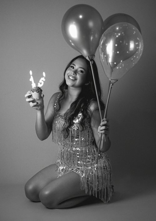 Free A young woman celebrates her 15th birthday with balloons and a cupcake in black and white. Stock Photo