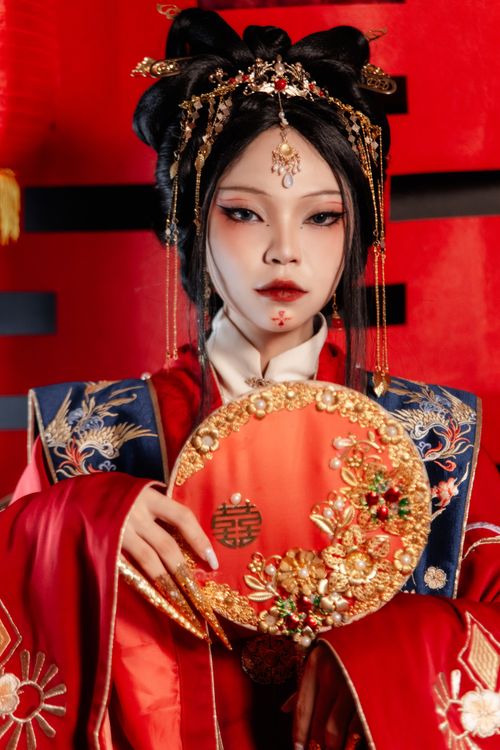 Free Striking portrait capturing a woman in ornate traditional Asian clothing with a decorative fan. Stock Photo