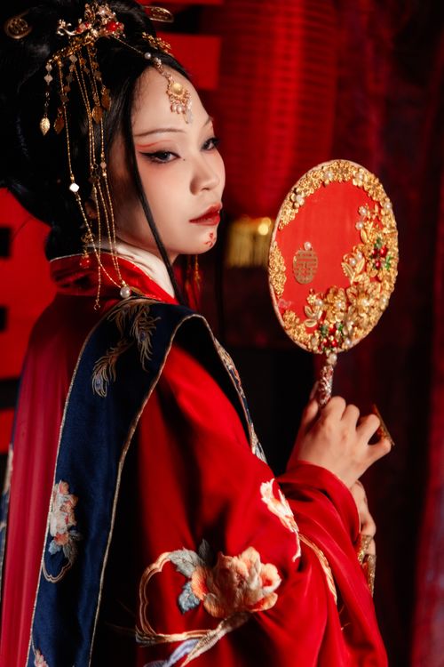 Free A portrait of an elegant woman in traditional Asian clothing holding a decorative fan, exuding grace and poise. Stock Photo