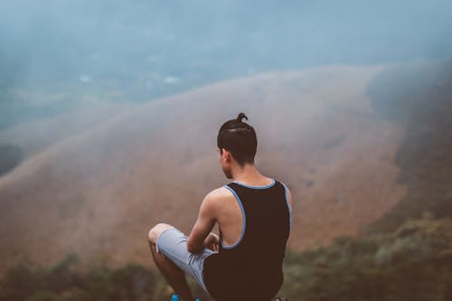 Man Sitting on Top of Hill