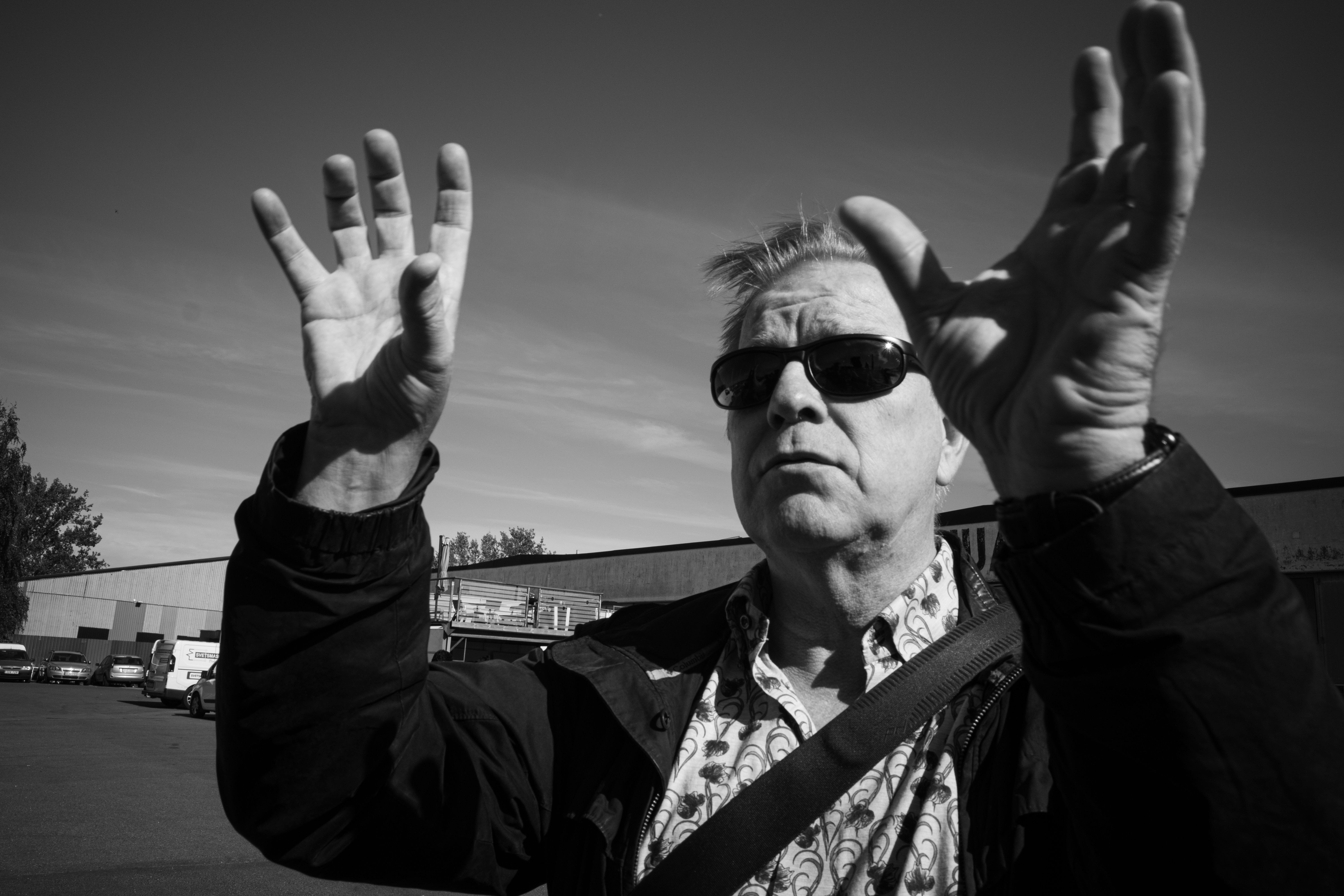 Man in Sunglasses with Hands Raised · Free Stock Photo