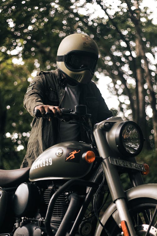 Man in a Helmet Standing next to a Motorcycle 