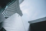 从低角度观察现代建筑立面，其几何设计与金属纹理尤为突出