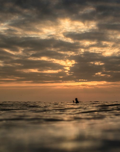 Free Silhouette of a swimmer in the ocean against a stunning sunset in Iquique, Chile. Stock Photo