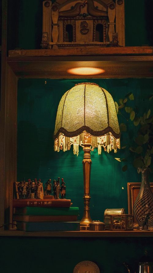 Free Warm, inviting vintage lamp on a shelf with decorative items, creating a cozy ambiance. Stock Photo