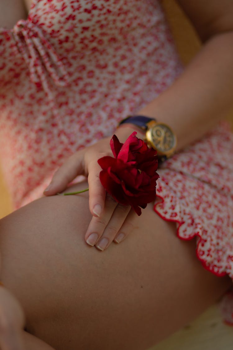 Woman Hand Holding Flower Over Leg