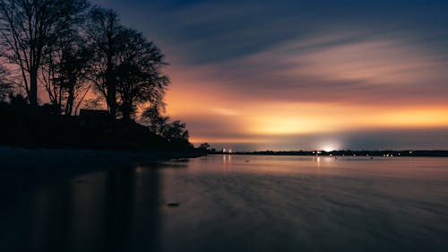 Evening Panorama with Trees and Houses at a Lake Shore