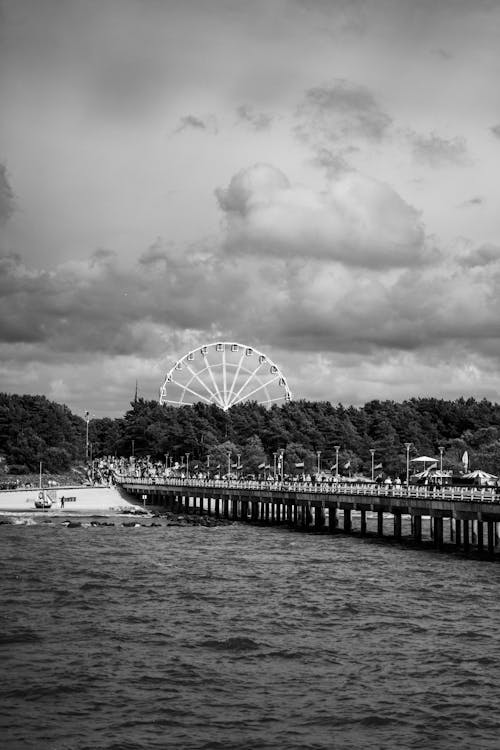 Pier on Sea Shore with Ferris Wheel behind