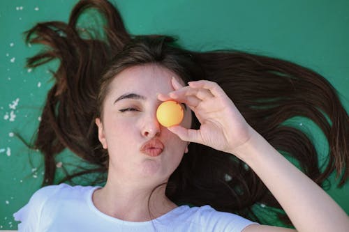 Woman Lying Down with Tennis Table Ball