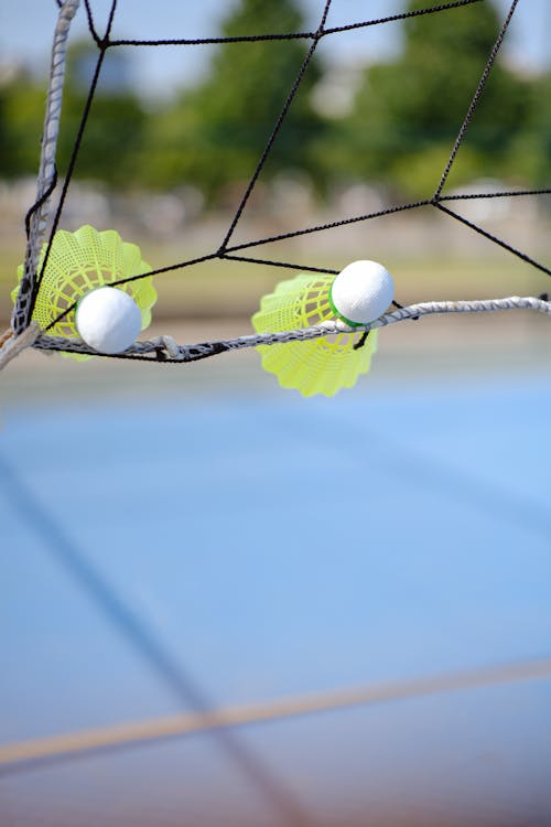 Yellow Badminton Shuttlecocks Sticking in a Net