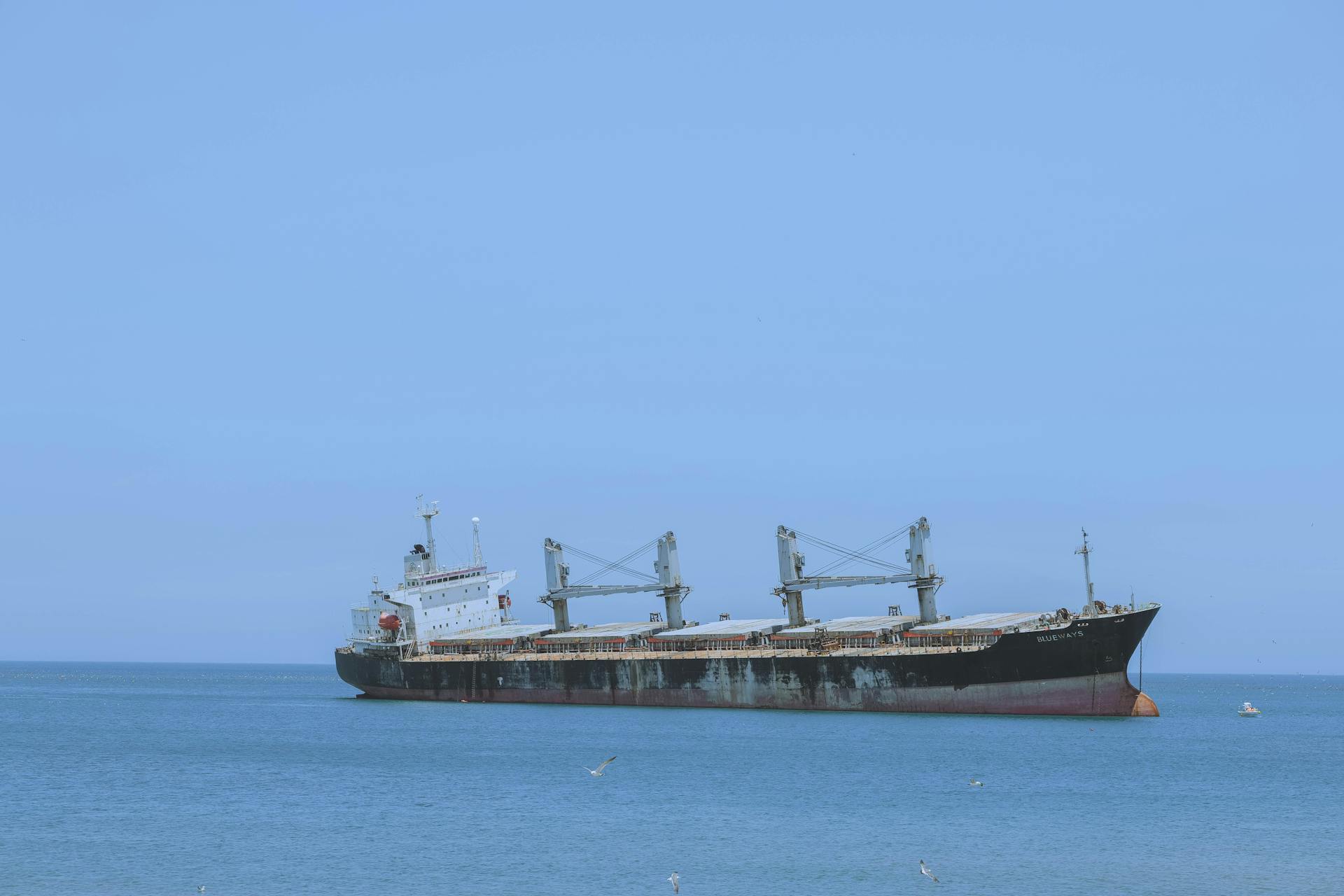 A cargo ship sails on the serene blue sea near Weihai, Shandong Province, China.