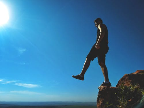 Free Man Standing on Cliff Stock Photo