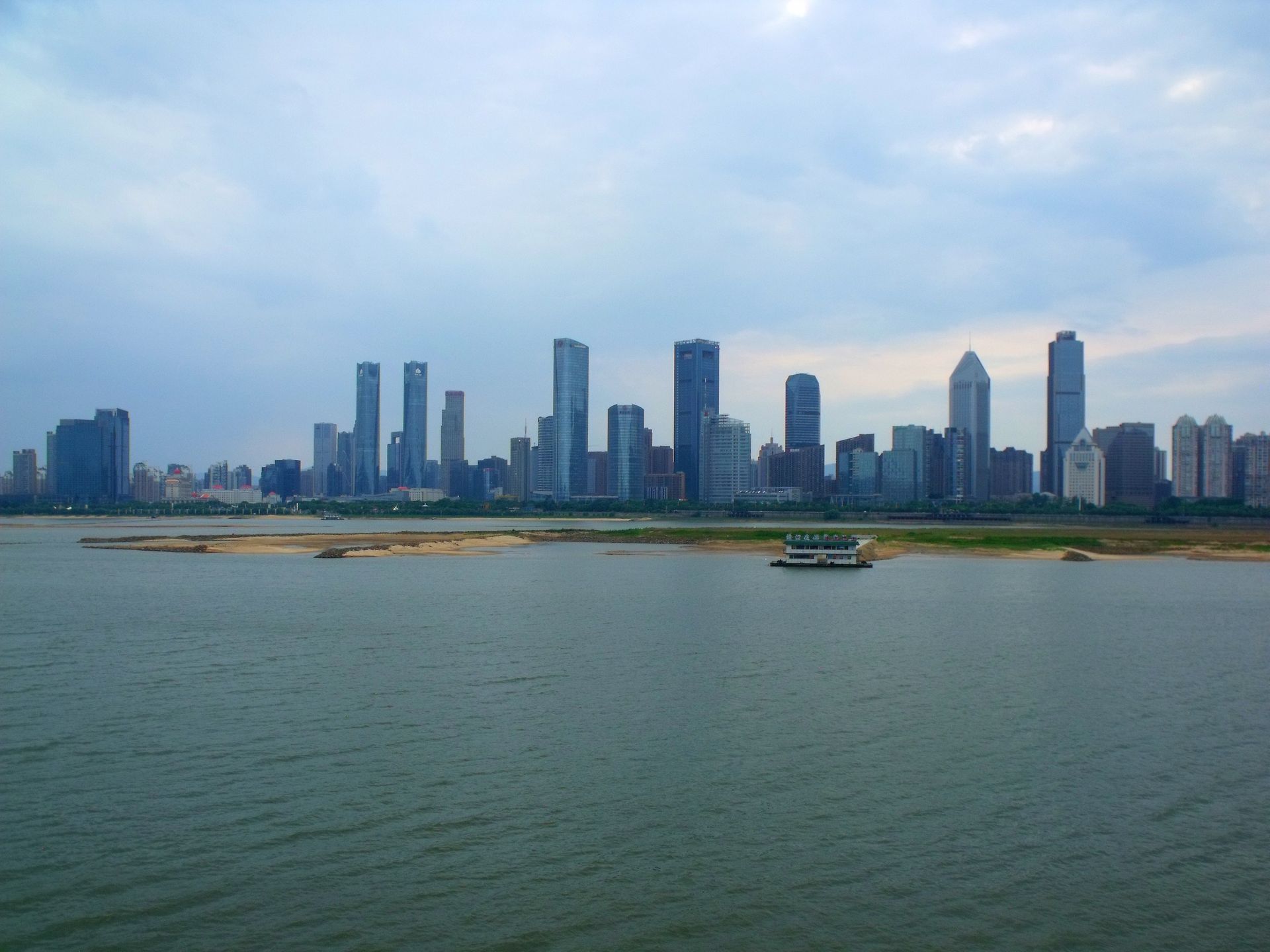 Panoramic view of Nanchang's skyline across the harbor with modern skyscrapers and river.
