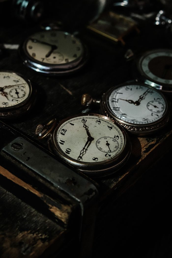 Collection of vintage pocket watches on dark wood, photo by Ejov Igor on Pexels