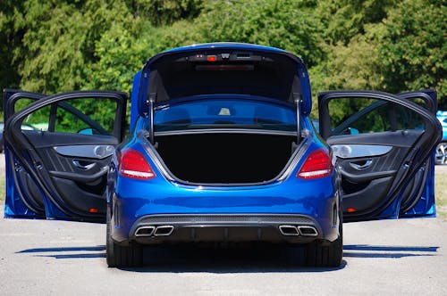 Rear View of a Blue Mercedes-Benz Car with Open Trunk and Doors