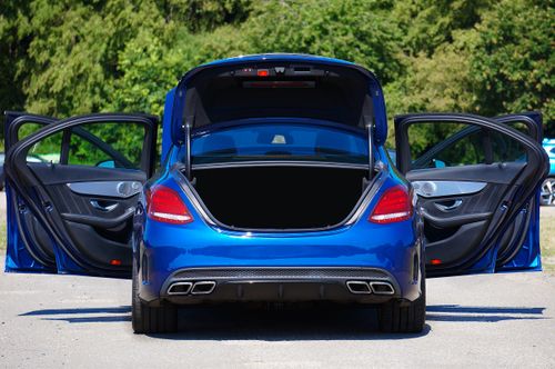 Free Blue luxury sedan with open doors and trunk parked in a lot. Stock Photo