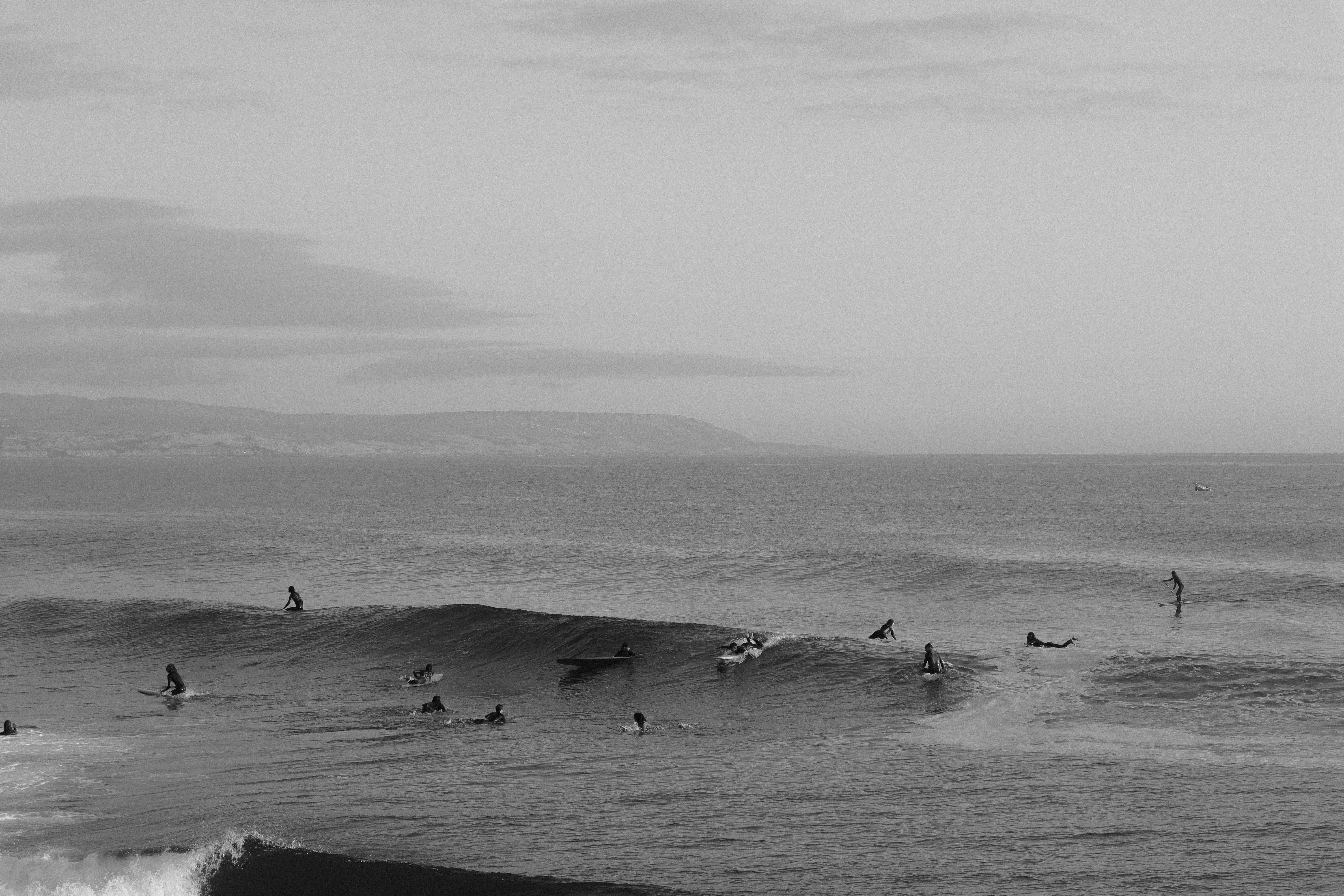 Black and white photo of surfers catching waves at Imsouane, Souss-Massa, Morocco.