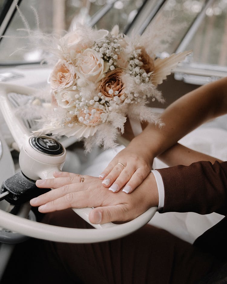 Hands With Wedding Rings On Steering Wheel