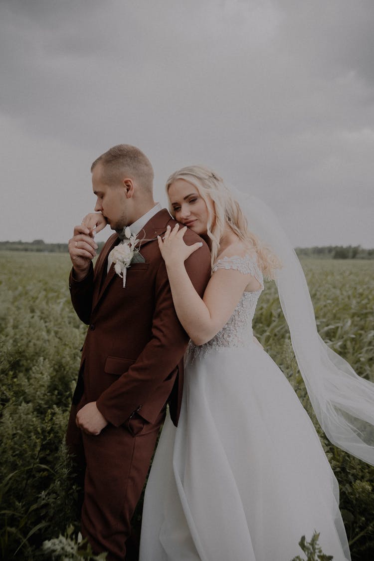 Newlyweds Standing Together In A Field